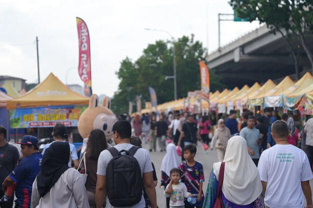 Bazaar crowds beneath the highway overpass — families gathering for iftar shopping