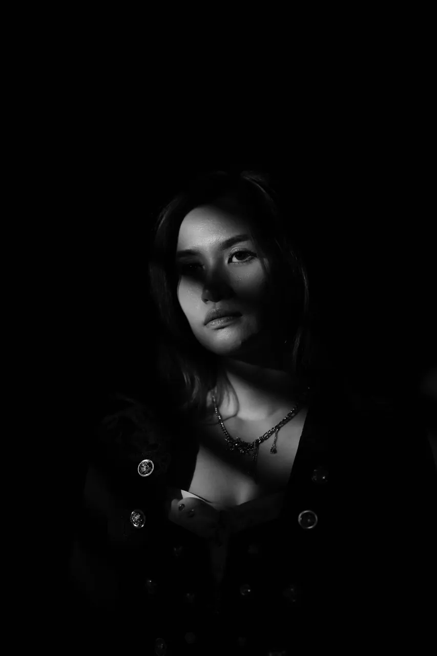 A single hard edge of light defining the face against black