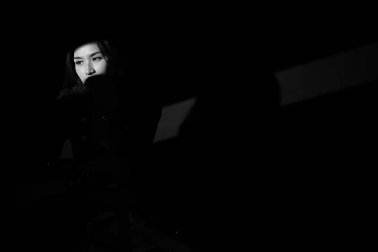 Low-key side light, subject emerging from shadow