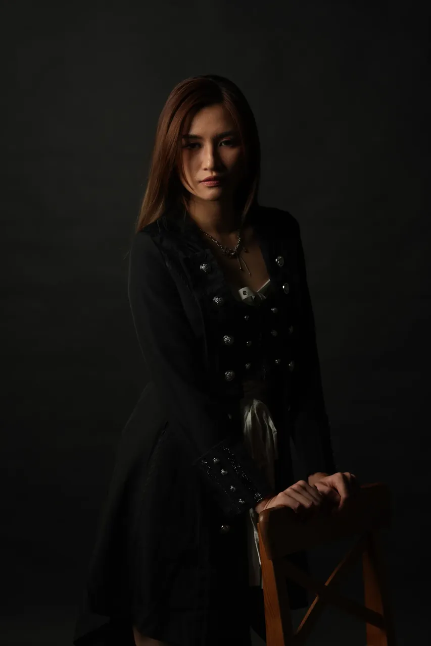 Hand resting on the chair, gaze off-camera