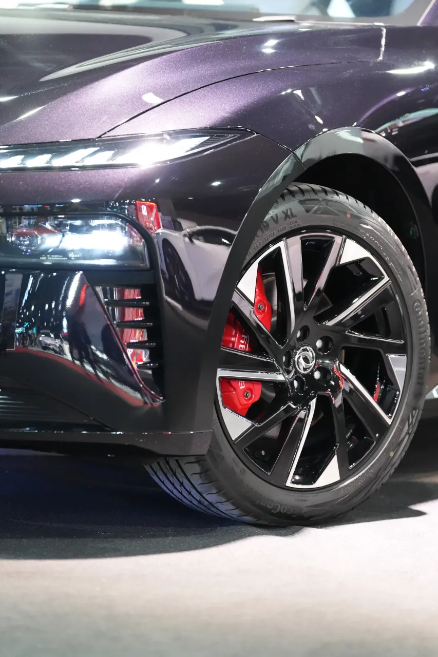 Rear three-quarter and alloy detail in low exhibition light