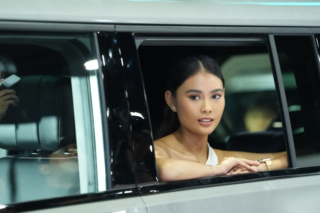 Presenter framed through an open car window