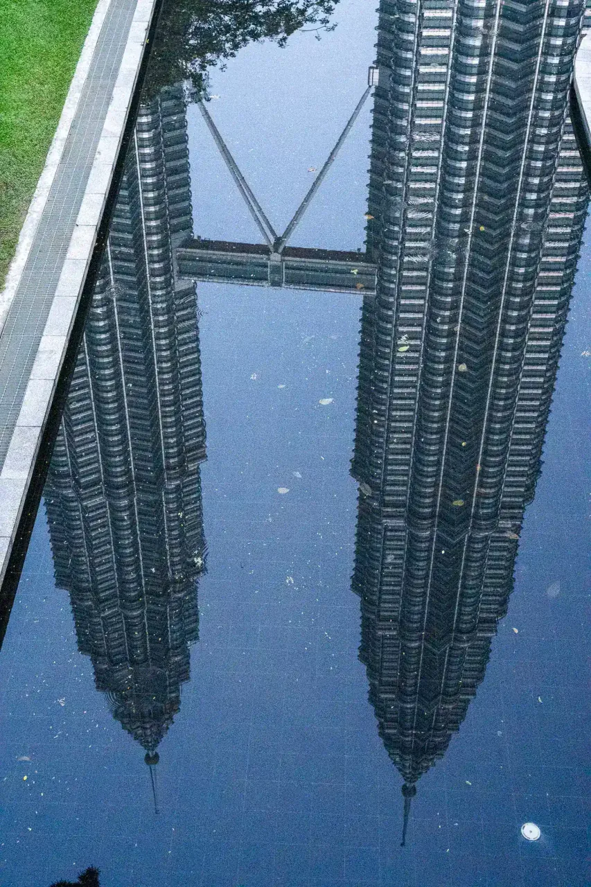 Petronas Tower reflection in KLCC Park lake at sunrise