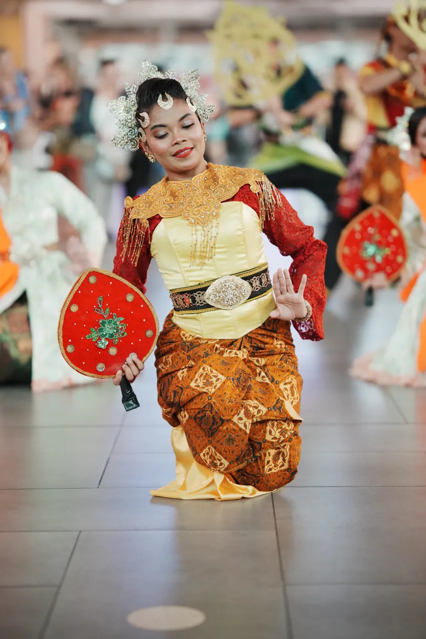 Serene moment — eyes closed, fan held in devotion during performance