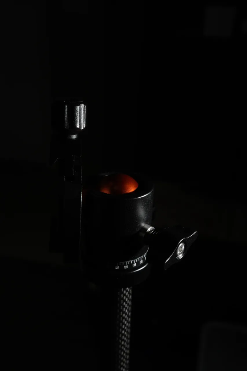 Product photography — tripod ball head detail in dark-field lighting