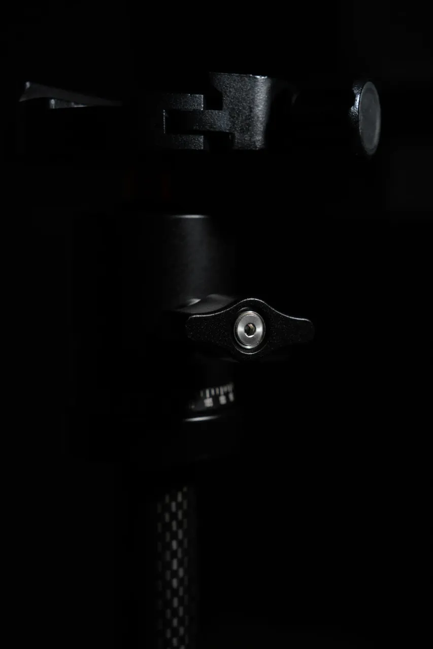 Macro product detail — precision tripod mechanism on black background
